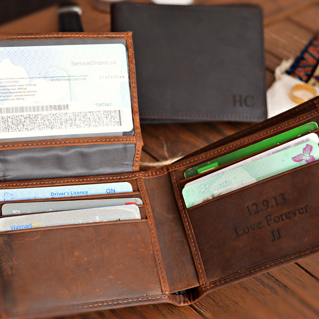 An open brown leather bi-fold wallet with card slots, ID window, and embossed text reading '12.9.