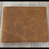 Brown leather wallet on a wooden surface