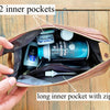 Open brown leather bag with two inner pockets and a long inner pocket with zipper, containing toiletries.