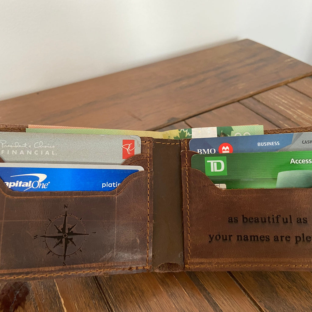 Brown leather wallet with cards on a wooden surface