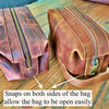 Two brown leather bags with zippers on a wooden surface