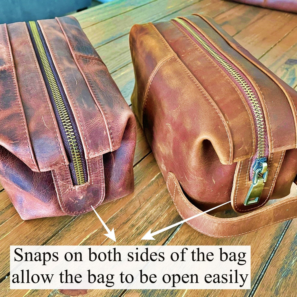Two brown leather bags with zippers on a wooden surface